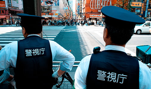 two policemen standing at the end of pedestrian lane during daytime thumbnail