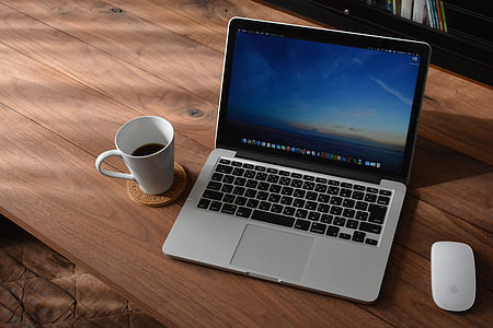 MacBook Pro and Magic Mouse on table thumbnail