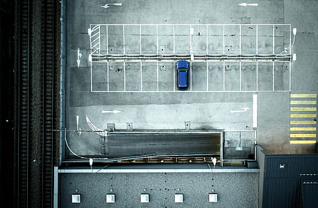 aerial view of blue car parked on parking lot thumbnail