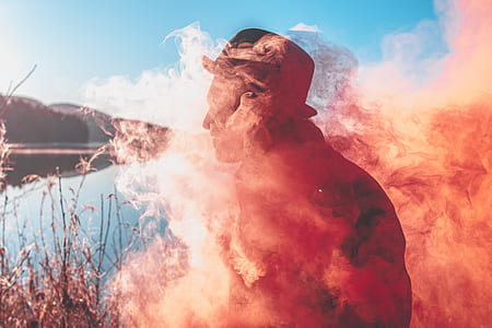 man in hat covered with orange smoke thumbnail