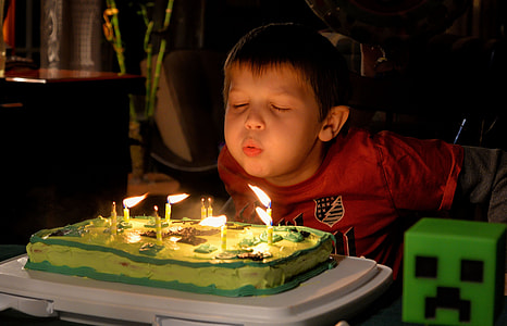 boy wearing red shirt blowing cake candles thumbnail