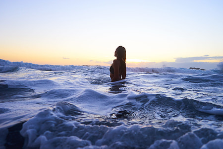 woman in body of water under blue sky thumbnail