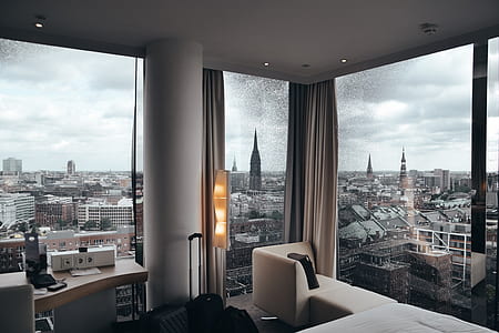 open window curtains and high rise buildings thumbnail