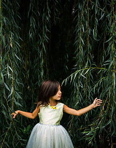 girl holding green leaf vine plants during daytime thumbnail