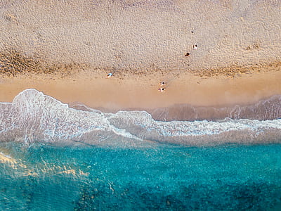aerial photo of people walking on beach during daytime thumbnail