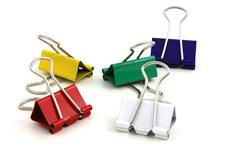 five assorted-color paper clips on white surface thumbnail