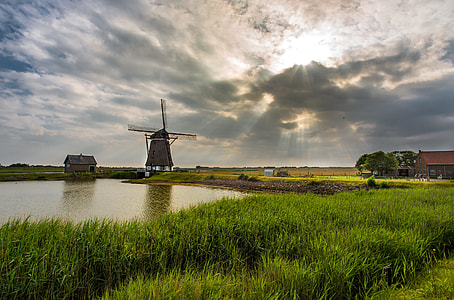 windmill beside body of water thumbnail