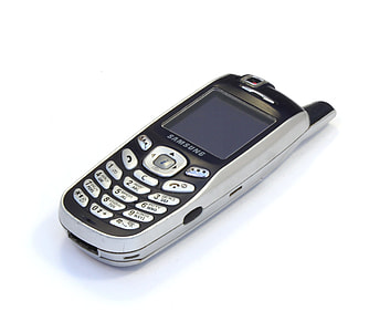 gray and black Samsung candybar phone on white background thumbnail