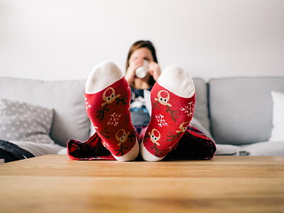 Woman Sitting on Sofa With Both Feet on Brown Wooden Coffee Table thumbnail
