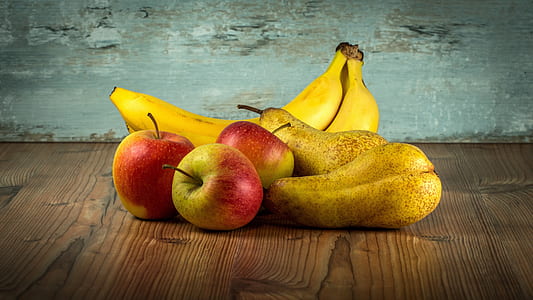 two bananas and three ripe apples on top of brown wooden surface thumbnail