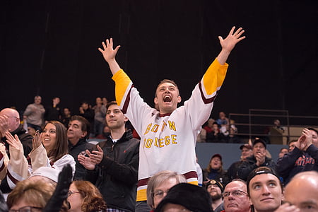 man raising arms in the middle of people thumbnail