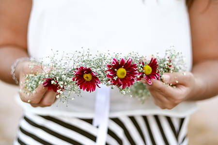 person holding green and red floral wreath thumbnail