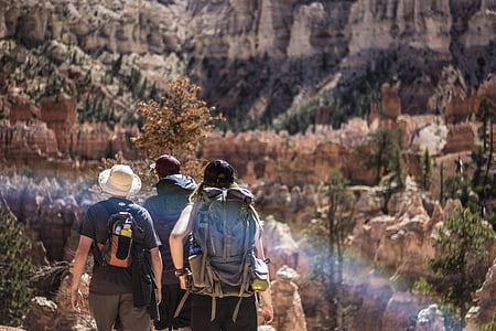 three people walking near mountains during daytime thumbnail