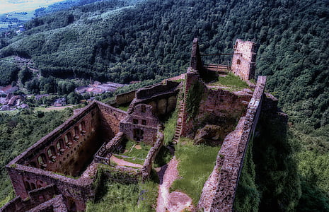 high angle photo of ruined building surrounded by trees and mountains thumbnail