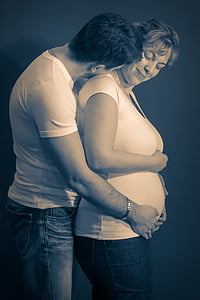 man hugging pregnant woman photo thumbnail