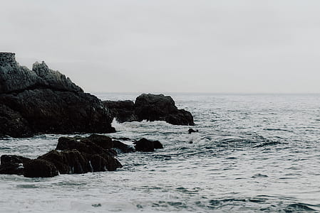 rock formation and calm sea during daytime thumbnail