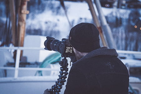 man using black DSLR camera thumbnail