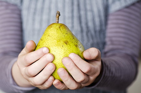 person holding yellow pear fruit thumbnail