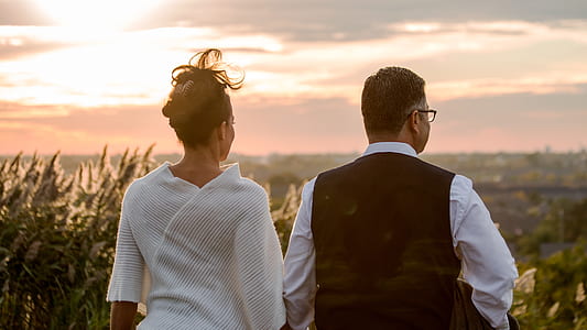 man and woman standing in front of green plants thumbnail