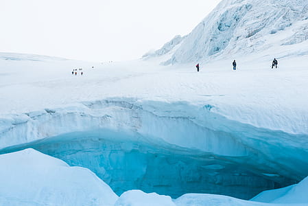 people standing on ice field near cliff thumbnail