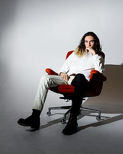 man sitting on rolling chair inside room thumbnail