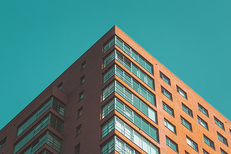 low angle photography of brown building under blue sky thumbnail
