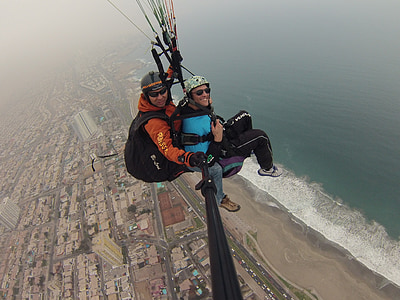 two people taking photo while flying above body of water thumbnail
