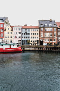 boat docked near a road during day time thumbnail