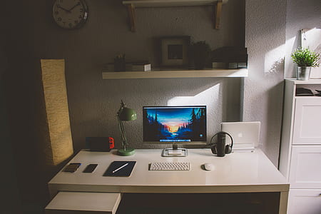 gray flat screen monitor and white wireless keyboard on computer table thumbnail