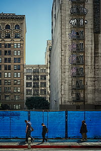 boy holding backpack walking beside fence thumbnail