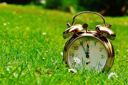 gold analog alarm clock reading time at 11:55 thumbnail