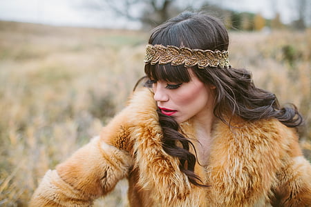 selective focus photography of woman in fur coat wearing headband thumbnail