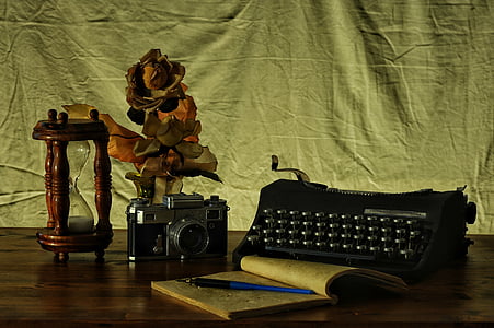 SLR camera and typwriter with notebook on table thumbnail
