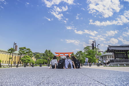 Four Girl's Sitting on Gray Concrete Floor Under Blue Sky thumbnail
