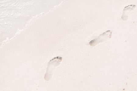 footprint on white sand beach during daytime thumbnail