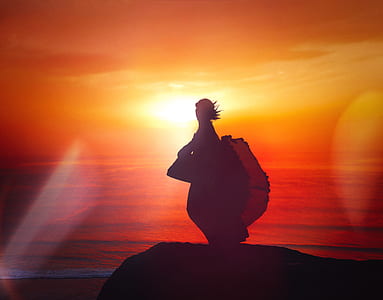 silhouette of person standing on cliff during sunset thumbnail