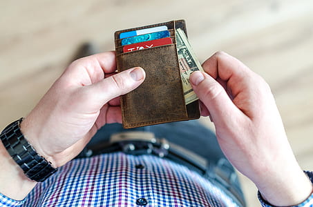 person holding brown wallet thumbnail