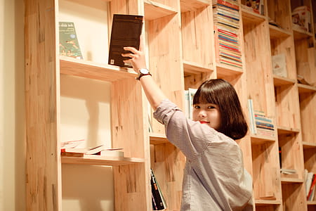 Woman Standing Beside Book Shelf thumbnail