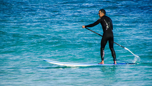 man using paddle board on body of water thumbnail