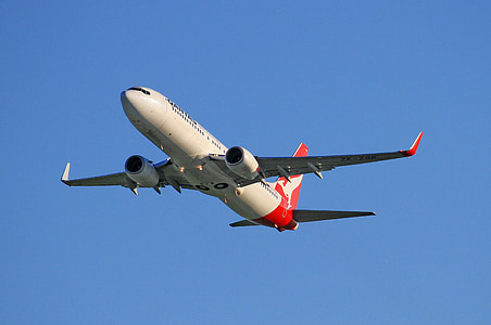 red and white passenger plane flying under blue clear sky during daytime thumbnail