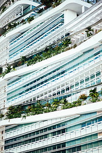 white concrete building with plants at daytime thumbnail