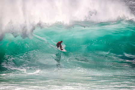 man surfing on blue ocean during daytime thumbnail