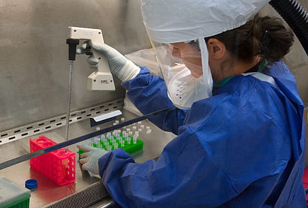 woman wearing blue laboratory dress holding white tester and test tube thumbnail