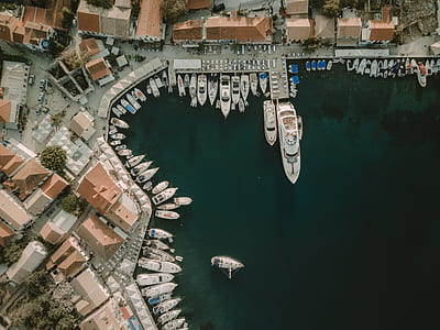 aerial photography of boat on sea beside houses during daytime thumbnail