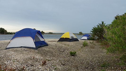 three blue and yellow dome tent near body of water during daytime thumbnail