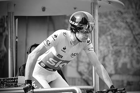 grayscale photo of man wearing helmet riding on bike thumbnail
