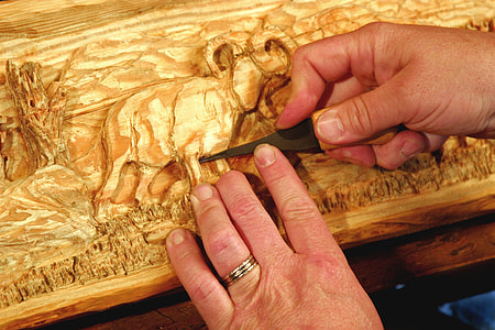 man carving on wooden deck thumbnail