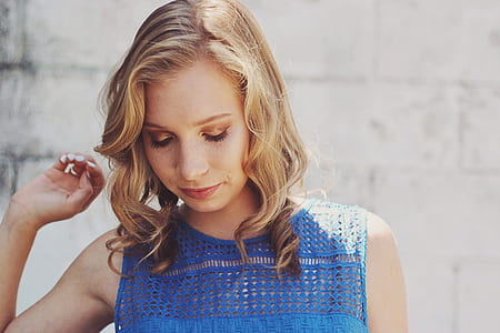 blonde haired woman wearing blue sleeveless top thumbnail