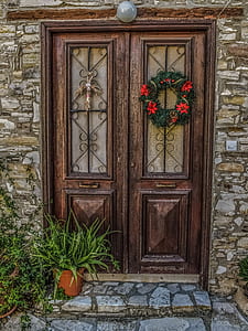 green and red wreath hanging on brown wooden door thumbnail