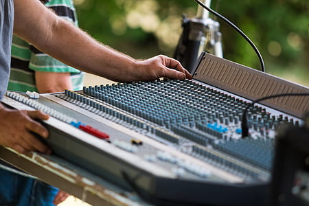 selective focus photography of man using mixing console thumbnail